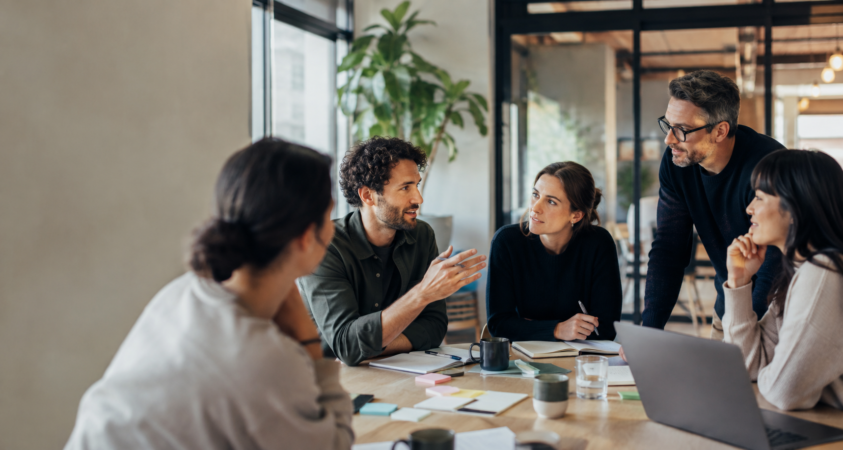 Equipo de trabajo intercambiando ideas alrededor de una mesa.